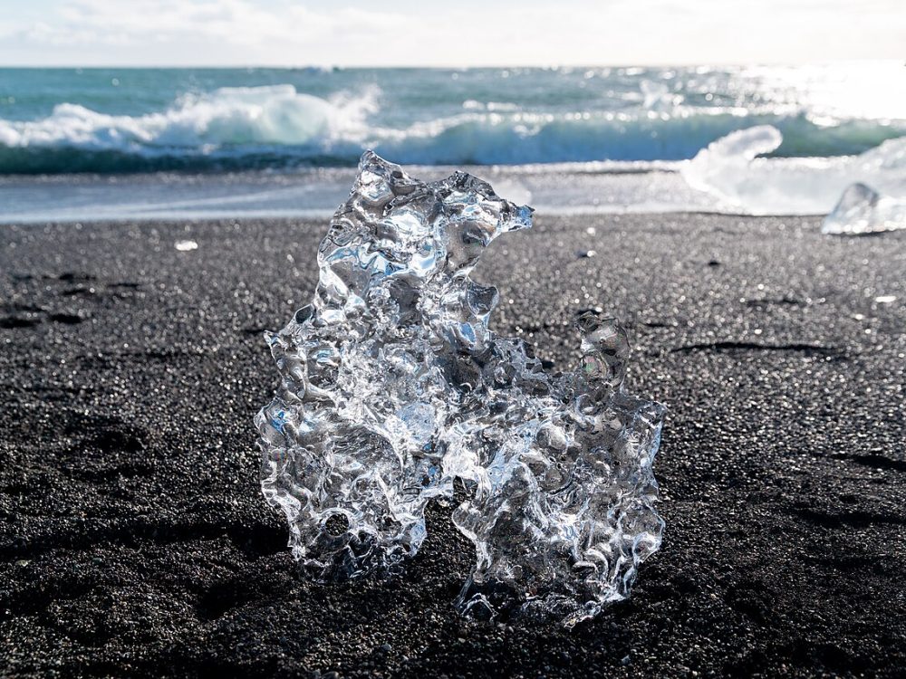 Stranded glacier ice on black basalt sand, catching the last of the light